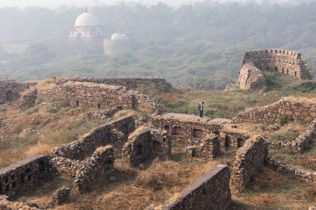 Image of ruined fort in Delhi India. A single man stands atop the wall. Image used to represent books catagorised as being about history and memory